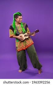 Studio Portrait Of Hippie Rasta Woman With Light Green Hair Playing Ukulele