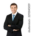 Studio portrait image of smiling young businessman in black suit and blue tie necktie, with crossed arms, isolated isolate over white background. Business man at studio picture. 