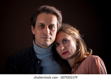 Studio Portrait Of Middle Aged Serious Couple On Dark Background