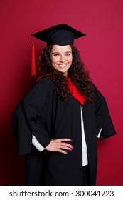 Studio Portrait Picture From A Young Graduation Woman On Red Background