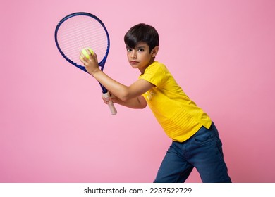 Studio portrait with pink background of a caucasian boy playing tennis - Powered by Shutterstock