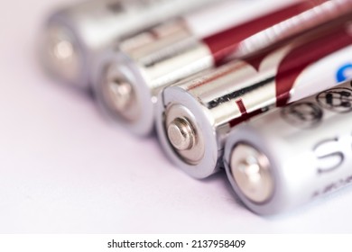 A Studio Portrait Of The Plus Or Positive Side Of A Couple Of Triple A Or AAA Batteries Lying On An Almost White Surface.