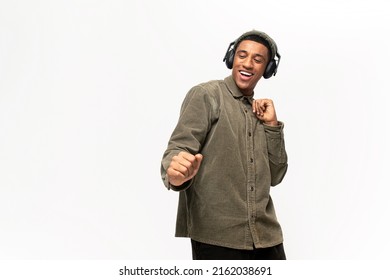 Studio Portrait Of Relaxed Cheerful Latin Man Wearing And Holding Wireless Headphones Isolated On White Wall, Enjoying Listening To Favourite Music Soundtrack, Wellbeing Concept