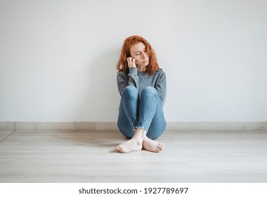 Studio Portrait Of Sad Young Woman On White Wall