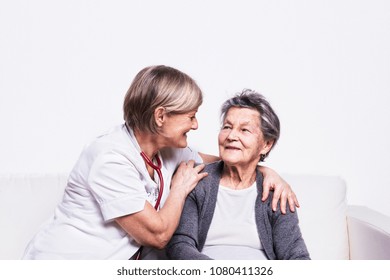 Studio Portrait Of A Senior Nurse And An Elderly Woman.