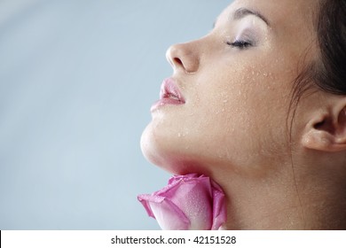 Studio Portrait Of Sensual Beautiful Woman With Rose And Water Droplets On Her Face