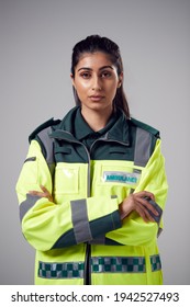 Studio Portrait Of Serious Young Female Paramedic Against Plain Background