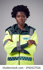 Studio Portrait Of Serious Young Female Paramedic Against Plain Background