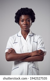 Studio Portrait Of Serious Young Female Nurse Wearing Uniform Against Plain Background