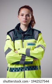 Studio Portrait Of Serious Young Female Paramedic Against Plain Background