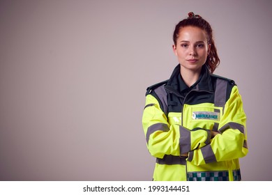 Studio Portrait Of Serious Young Female Paramedic Against Plain Background