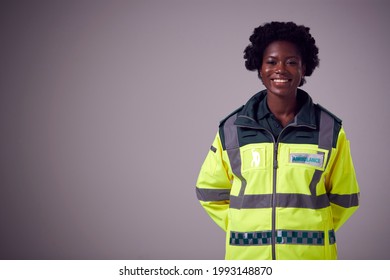 Studio Portrait Of Serious Young Female Paramedic Against Plain Background