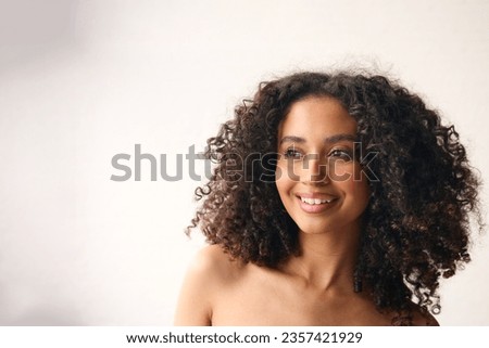 Studio Portrait Of Smiling Natural Woman With Bare Shoulders Standing Against Neutral Background