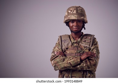 Studio Portrait Of Smiling Young Female Soldier In Military Uniform Against Plain Background - Powered by Shutterstock