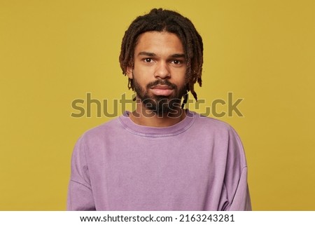 Studio portrait of young african american man posing over studio background looking into camera with calm facial expression Stock photo © 