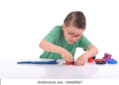 Studio Portrait Of Young Boy  Playing With Modeling Clay Or Play Doh