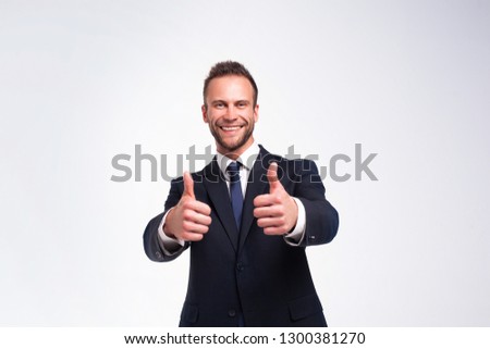 Studio portrait of young handsome businessman showing thumbs up gesture isolated on white background