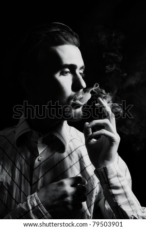 Studio portrait of a young man smoking a cigarette