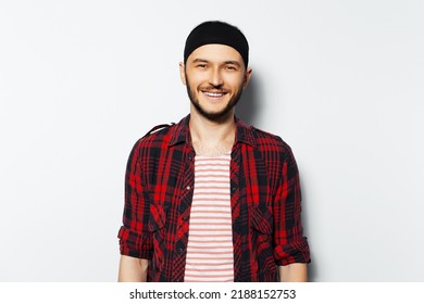 Studio Portrait Of Young Smiling Man On White Background. Wearing Red Casual Clothes And Black Head Band. Happiness Guy.