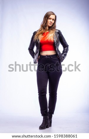 studio portrait of a young woman in a leather jacket on a white background
