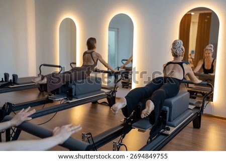Studio reformer class dynamics, energetic group pilates reformer session with focused movement