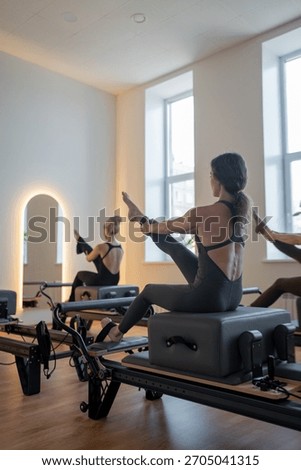 Studio reformer class dynamics, energetic group pilates reformer session with focused movement