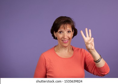 Studio Set Of Middle Age Woman Holding Up Three Fingers