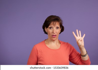 Studio Set Of Middle Age Woman Holding Up Four Fingers