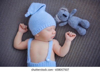 Studio Shoot Of Cute 10 Days Old Newborn Baby Sleeping On His Back On A Soft Blanket In A Blue Hat And Funny Panties