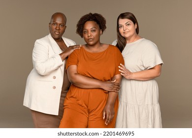 Studio Shot Of An African American Woman In Her 30's, A Black Woman In Her 50's, And A Middle Eastern Woman In Her 40's Standing Confidently On A Neutral Background.