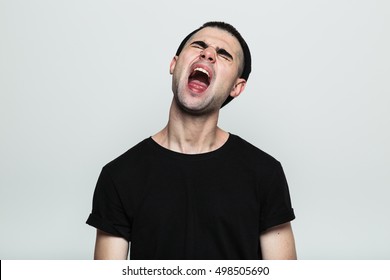 Studio Shot Of An Annoyed Man Screaming, His Head Tilted Back