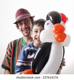 Studio Shot Of Balloon Twister And Little Boy With Penguin.