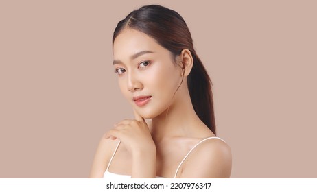 Studio shot of Beautiful young Asian woman with clean fresh skin on brown background, Face care, Facial treatment, Cosmetology, beauty and spa.