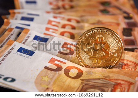 Studio shot of bitcoin physical golden coin on 50 euro bills banknotes. Bitcoin is a blockchain crypto currency