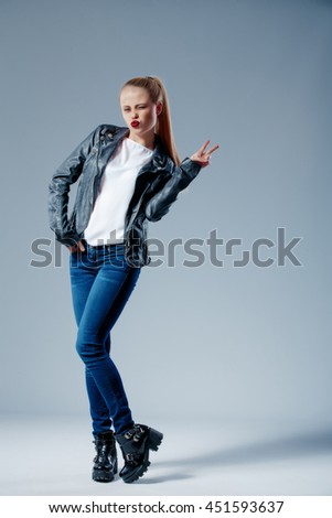 Studio shot of blonde model pulling her hair while looking at camera with grin.Isolated