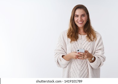 Studio Shot Charming Happy Smiling Woman Holding Smartphone Looking Camera Positive Grinning Communicating Using App Featurused. Female Blogger Posting Pic Online Smm Working Via Phone