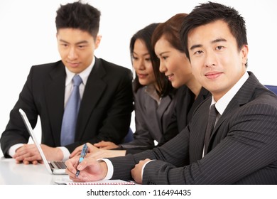 Studio Shot Of Chinese Businesspeople Having Meeting