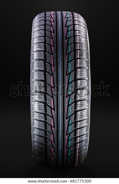 studio shot of a clean winter car tire over a\
dark background