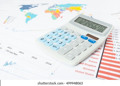 Studio shot of data graphs and charts with calculator over it