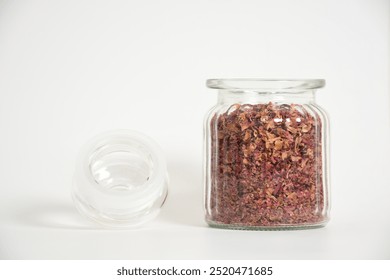 Studio shot of dry rose petals tea on white background. Selektive focus. Dehydrated Rose petals in a glass jar in white background. Dried flower petals. Floral concept. Natural herbal cosmetics. - Powered by Shutterstock