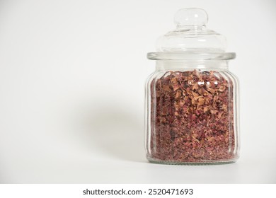 Studio shot of dry rose petals tea on white background. Selektive focus. Dehydrated Rose petals in a glass jar in white background. Dried flower petals. Floral concept. Natural herbal cosmetics. - Powered by Shutterstock