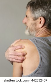 Studio Shot Of Elderly Man With Shoulder Pain