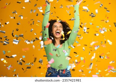 Studio Shot Of Excited Woman Celebrating Big Win Showered In Tinsel Confetti On Yellow Background - Powered by Shutterstock