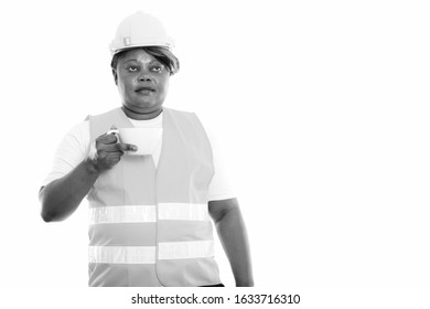 Studio Shot Of Fat Black African Woman Construction Worker Thinking While Holding Coffee Cup