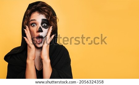 A studio shot of a girl expressing fright in a costume of evil spirits at a Halloween costume party. Empty space for goods, advertising. The Art of Halloween
