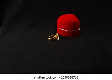 Studio Shot Of A Golden Ring With Red Ring Box Isolated On Background. A High Angle View Of Ring And Heart Shape Ring Box With Copy Space. 