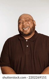 Studio Shot Of A Gorgeous Multiracial Man In His 50's Laughing On A White Seamless.