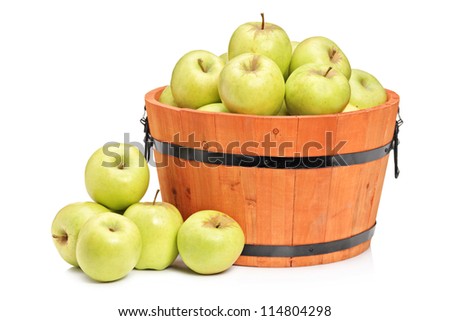 A studio shot of green apples in a wooden basket isolated on white background