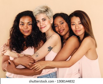 Studio Shot Of A Group Of Beautiful Young Women Hugging Each Other