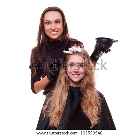 studio shot of hairdresser dyeing woman's hair. isolated on white